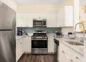 Thumbnail 22 of 28 - a kitchen with stainless steel appliances and white cabinets at Residences at Stevens Pond, Saugus, Massachusetts 01906