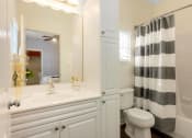 Thumbnail 18 of 28 - a white bathroom with a black and white shower curtain at Residences at Stevens Pond, Massachusetts