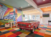Thumbnail 9 of 28 - a pool table in a room with a car at Residences at Stevens Pond, Saugus