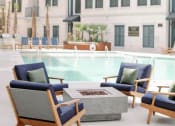 Thumbnail 19 of 39 - a swimming pool with chairs and a fire pit at The Merchant Apartments, South Carolina 29403