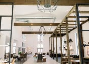 Thumbnail 24 of 39 - Market-style resident lounge with comfortable seating and wood beaming along the ceilings at The Merchant Apartments, South Carolina