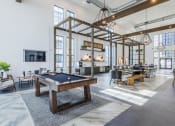 Thumbnail 27 of 39 - Chic resident lounge area with a pool table in the middle at The Merchant Apartments, Charleston, South Carolina