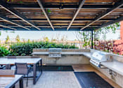 Thumbnail 41 of 55 - A patio with a table and chairs under a roof.