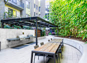 Thumbnail 36 of 55 - A patio with a table and chairs under a roof.