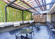 Thumbnail 34 of 55 - A patio with a table and chairs is surrounded by a bamboo wall.