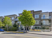 Thumbnail 1 of 28 - a picture of an apartment building with a blue car parked in front of it at 128 on State, Kirkland, 98033