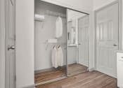 Thumbnail 17 of 40 - a walk in closet with white robes and a mirrored closet door at Aston at Cinco Ranch, Katy, 77450