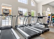 Thumbnail 33 of 40 - two rows of treadmills in a gym with windows at Aston at Cinco Ranch, Katy, TX, 77450