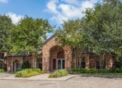 Thumbnail 26 of 40 - the facade of a brick house with an arch and trees at Aston at Cinco Ranch, Katy, 77450