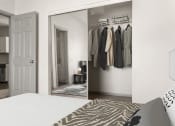 Thumbnail 7 of 40 - a bedroom with a bed and a closet with a mirror at Aston at Cinco Ranch, Katy, TX