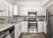Thumbnail 1 of 40 - a kitchen with stainless steel appliances and white cabinets at Aston at Cinco Ranch, Katy, Texas