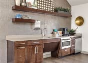 Thumbnail 21 of 32 - a kitchen with wooden cabinets and a sink and a stove at Arcadia Apartments, Centennial, CO 80112