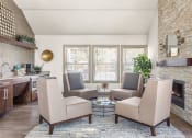 Thumbnail 23 of 32 - a living room with chairs and a table and a fireplace at Arcadia Apartments, Centennial
