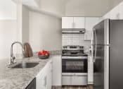 Thumbnail 9 of 32 - a kitchen with stainless steel appliances and granite counter tops at Arcadia Apartments, Centennial, 80112