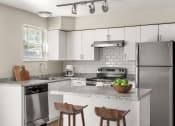 Thumbnail 10 of 32 - a kitchen with stainless steel appliances and a marble counter top at Arcadia Apartments, Centennial, Colorado