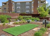 Thumbnail 29 of 32 - a garden with a lawn in front of an apartment building at Arcadia Apartments, Centennial, CO 80112