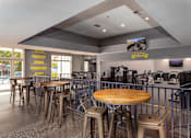 Thumbnail 16 of 19 - A restaurant with tables and chairs and a bar area.