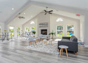 Thumbnail 15 of 19 - A spacious living room with a fireplace and a ceiling fan.