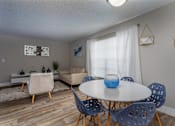 Thumbnail 1 of 19 - A dining room with a white table and blue chairs.