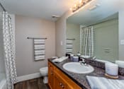 Thumbnail 6 of 19 - A bathroom with a toilet, sink, and a shower curtain.