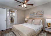 Thumbnail 4 of 19 - A bedroom with a bed, two lamps, and a painting on the wall.