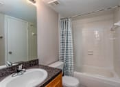 Thumbnail 7 of 19 - A bathroom with a sink, toilet, and bathtub.