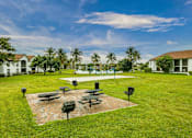 Thumbnail 14 of 19 - A park with a grassy area, benches, and a brick pathway.