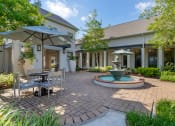 Thumbnail 17 of 30 - a patio with a fountain and a table and chairs at Summerwind, Pearland Texas