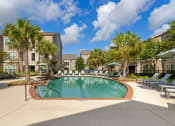 Thumbnail 22 of 30 - a swimming pool with palm trees in front of a building at Summerwind, Pearland