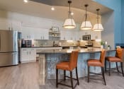 Thumbnail 15 of 30 - a kitchen with a large island with three chairs at Summerwind, Pearland, TX 77584
