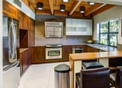 Thumbnail 16 of 25 - a spacious kitchen with a wooden ceiling and white tiles on the floor at The Lakes Apartments, Bellevue