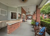 Thumbnail 21 of 29 - commons front porch with seating and a brick wall at Veranda at Centerfield, Texas