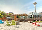 Thumbnail 2 of 21 - Beach chairs are arranged on a sandy beach at Skye at Belltown Apartments, Seattle, Washington