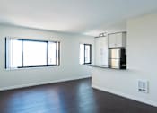 Thumbnail 4 of 21 - A large empty room with wooden floors and a large window at Skye at Belltown Apartments, Seattle, WA 98121