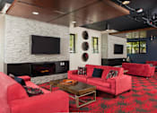 Thumbnail 13 of 21 - A living room with a fireplace and a television at Skye at Belltown Apartments, Washington