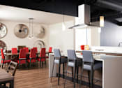 Thumbnail 15 of 21 - A modern kitchen with a bar area and chairs at Skye at Belltown Apartments, Washington