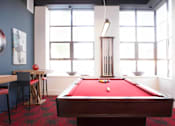 Thumbnail 16 of 21 - A pool table is in the middle of a room with a bar and a window at Skye at Belltown Apartments, Washington 98121