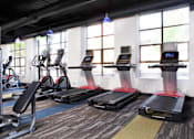 Thumbnail 7 of 21 - A gym with treadmills, elliptical machines, and other cardio equipment at Skye at Belltown Apartments, Seattle