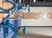 Thumbnail 20 of 21 - A blue bicycle is parked in front of a wall with bike racks at Skye at Belltown Apartments, Seattle