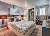 Thumbnail 18 of 25 - A bedroom with a large bed with a grey quilted duvet cover and a painting on the wall at Brackett Apartments, Edmonds, 98020
