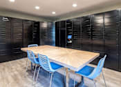 Thumbnail 12 of 25 - A conference room with a wooden table and blue chairs at Brackett Apartments, Washington