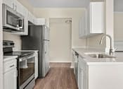 Thumbnail 8 of 28 - a renovated kitchen with white cabinets and stainless steel appliances at Villages of Cypress Creek, Texas, 77070