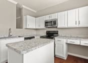 Thumbnail 1 of 28 - a kitchen with white cabinets and granite counter tops at Villages of Cypress Creek, Texas, 77070