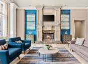 Thumbnail 18 of 28 - a living room with blue and white furniture and a fireplace at Villages of Cypress Creek, Houston, TX, 77070