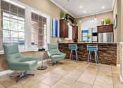 Thumbnail 19 of 28 - a living room with a kitchen with a bar and chairs at Villages of Cypress Creek, Houston