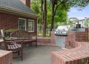 Thumbnail 17 of 28 - a brick patio with a barbecue grill and a wooden bench at Villages of Cypress Creek, Houston, 77070