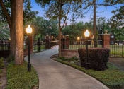 Thumbnail 26 of 28 - a walkway through a park with lamps and a fence at Villages of Cypress Creek, Texas, 77070