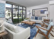 Thumbnail 10 of 22 - a living room with white couches and chairs and large windows at District West Gables, West Miami, Florida 33155