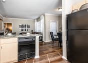 Thumbnail 15 of 33 - a kitchen and living room with a refrigerator and a sink at The links at Plum Creek Apartments, Colorado