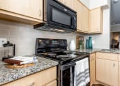 Thumbnail 14 of 33 - a kitchen with black appliances and granite counter top